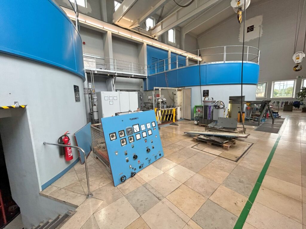 The old control panel of the Oberelchingen facility. Visible in the background are the switchgear cabinets with the modern machine controls.
