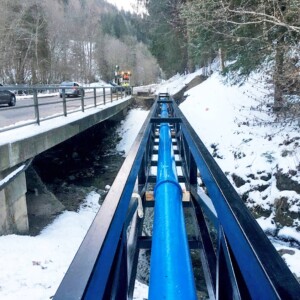 The upper penstock section is made up of PVC pipes by Spanish-based manufacturer Molecor. Traversing the Weizbach via a pipe bridge, the lower half of the power descent uses ductile cast iron pipes to withstand the higher pressure conditions. All the basic materials for them were provided by Geotrade Tiefbauprodukte GmbH. Wasserkraftwerk Weizbach Rohrbrücke